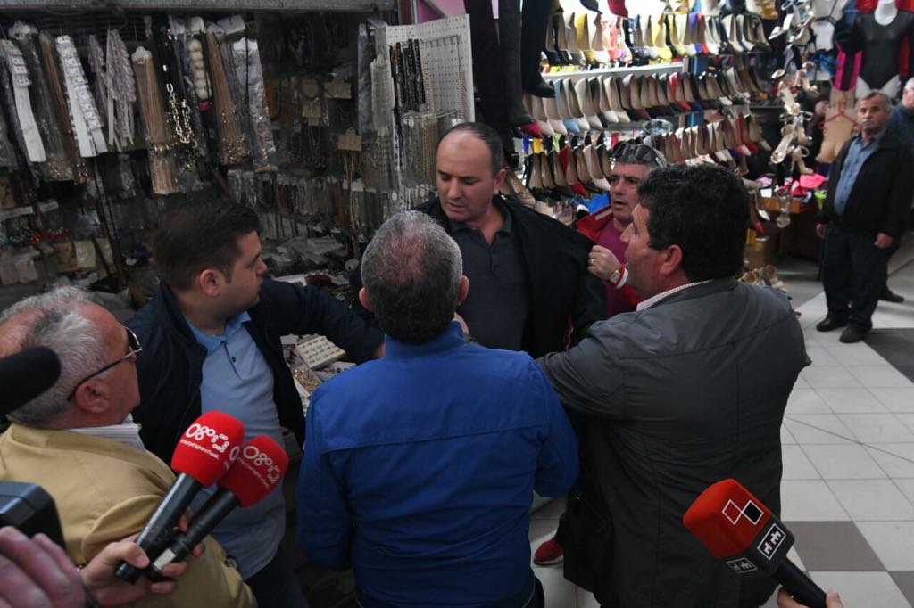 FOTOT/ Incidenti: Deputetët e PD dhe LSI përplasen fizikisht me tregtarët që nuk ulin qepenat