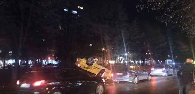 Aksidenti i pazakontë në Tiranë, taksia përmbyset në mes të rrugës